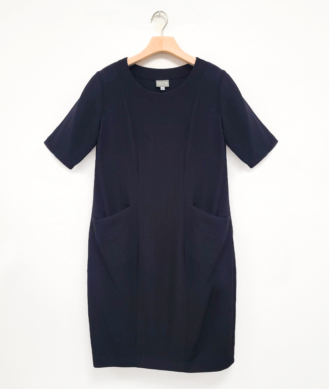 black shift dress with princess seams, elbow length sleeves and hip pockets set in to the seams