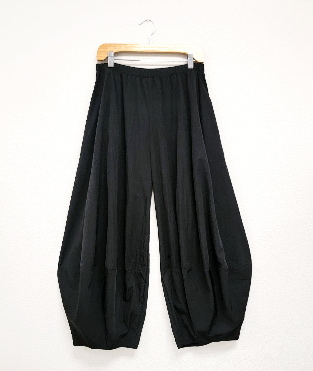 wide leg black pant with an elastic waist and a taperd ankle, creating a tulip shaped silhouette