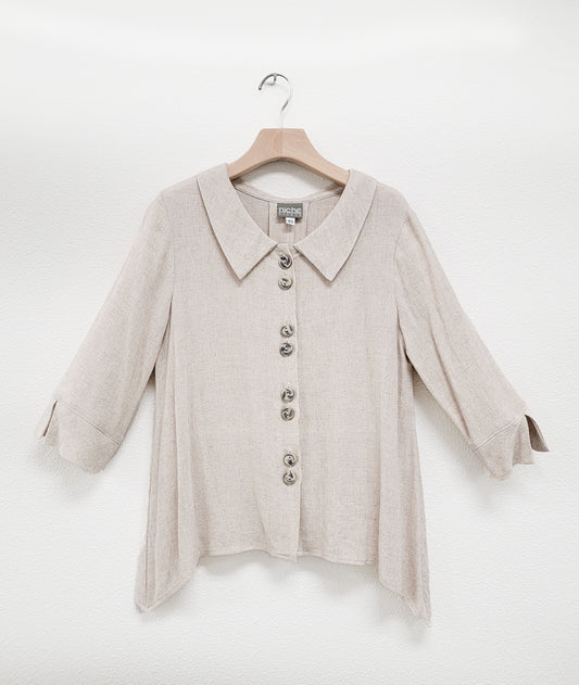 oatmeal color blouse with 3/4 sleeves, a dipped hem and double sets of buttons