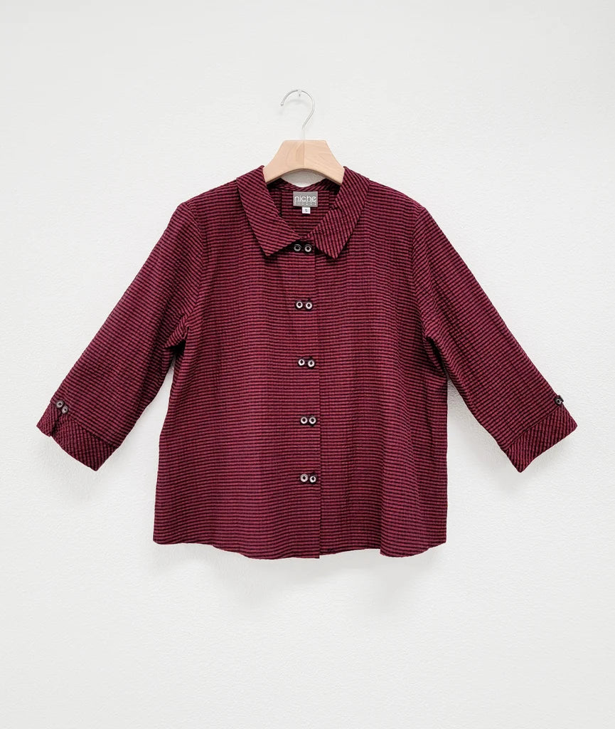 3/4 sleeve red and black stripe top with "twin" buttons, collar, and buttons at end of sleeves against white background