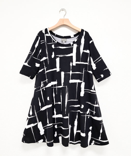 black jersey dress with a white brushstroke print. dress has 3/4 sleeves, a rounded neckline and a full swingy body