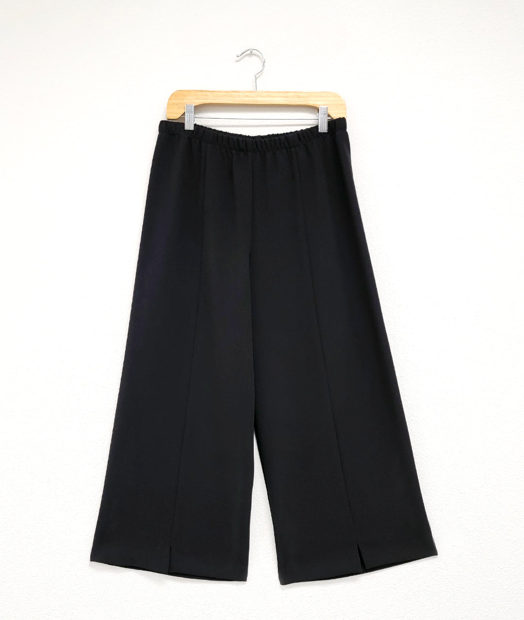 black wide leg pant with an elastic waistband, center front seams and a split at each ankle