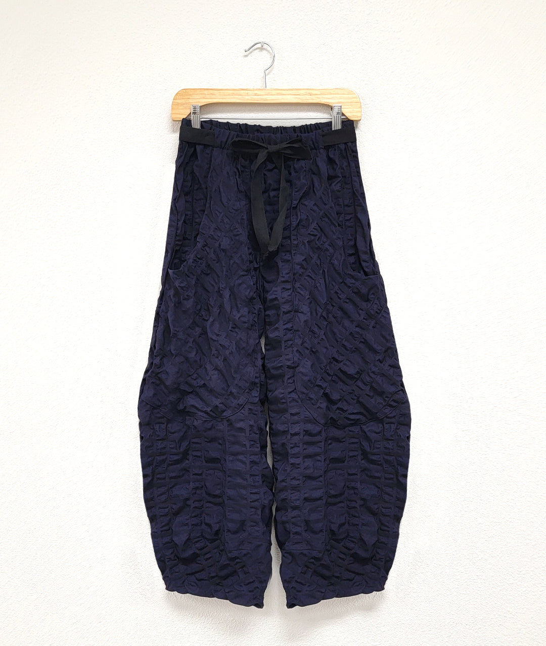 dark blue wide leg pant with oversized pockets, tapered ankles and a tie belt