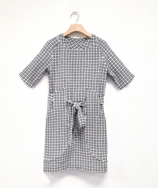 black and white check print raglan sleeve shift dress with a matching tie belt at the waist, which runs through exterior pocket loops