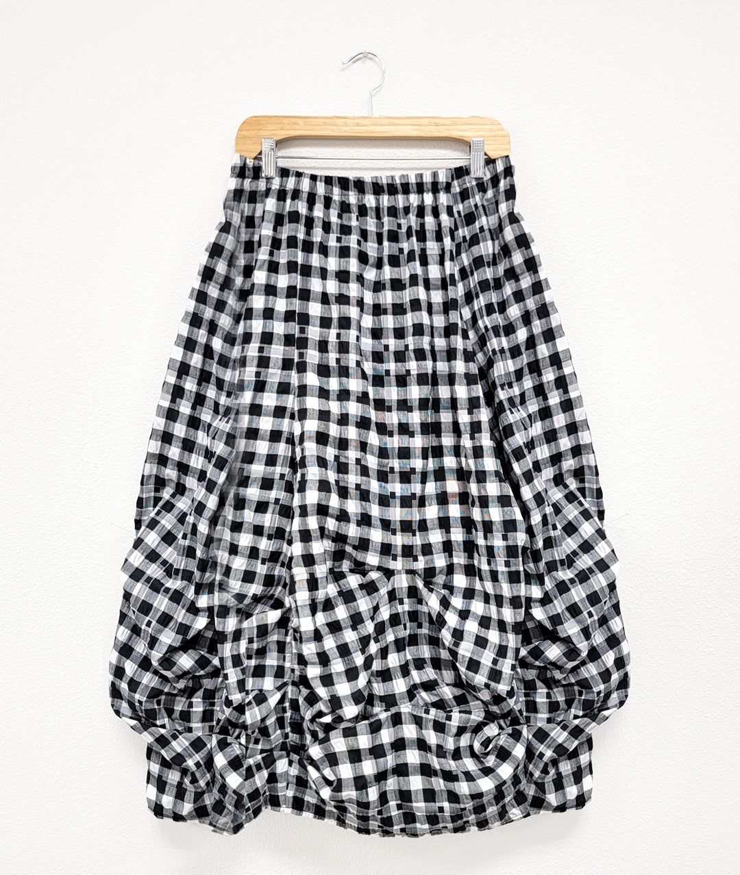 black and white plaid skirt with tucks along the center front and side seams creating a bubbled silhouette