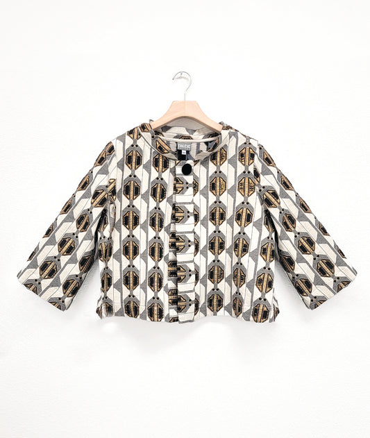 ivory, gold and black pattern design jacket with single button on hanger with white background.