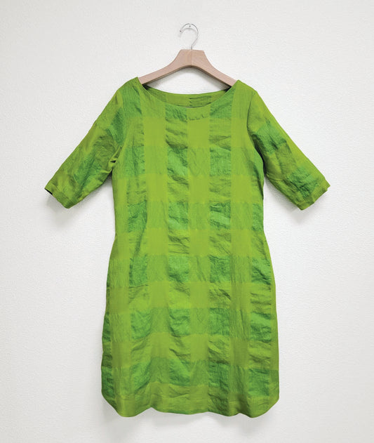 oversized lime shift dress with a round neckline, 3/4 sleeves, a curved hem and a large check print weave giving the fabric differing shades of green