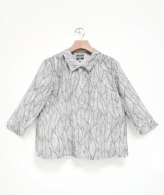 white button down blouse with a grey leaf print. blouse has a cropped, boxy body, 3/4 sleeves and a twinbutton detail