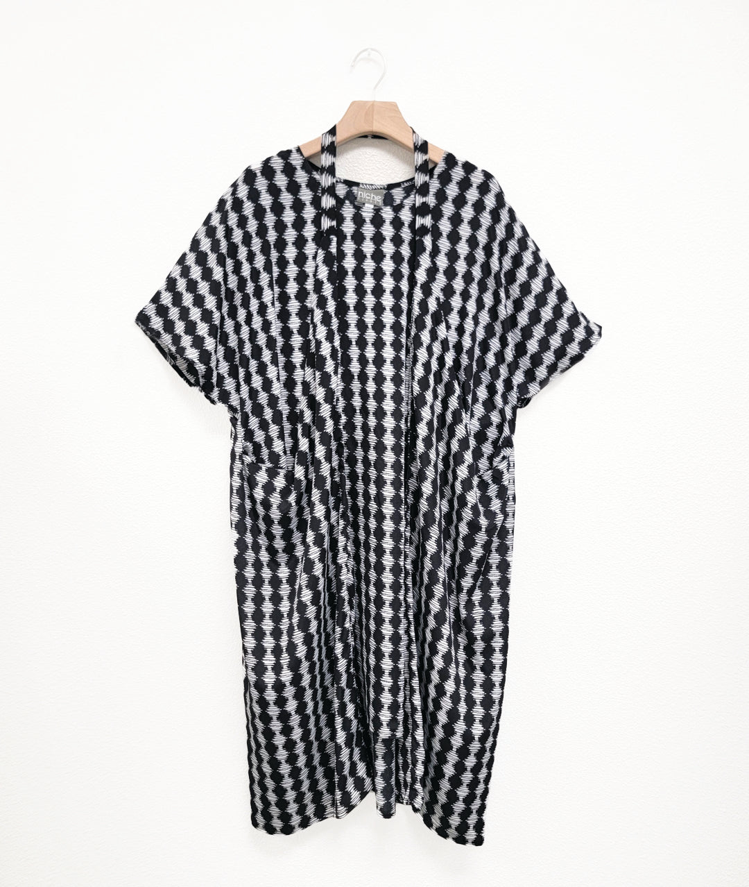 black and white diamond stripe tunic with a strap from the hips worn around the neck