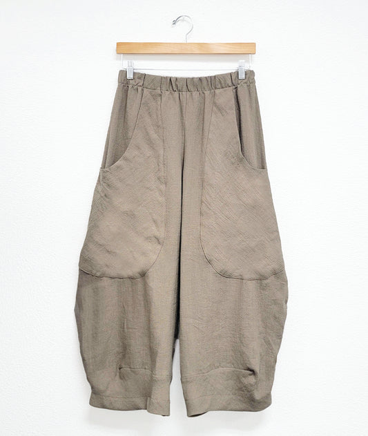 taupe color mini grid print wide leg pant with a tapered ankle, oversized exterior pockets, and an elastic waistband