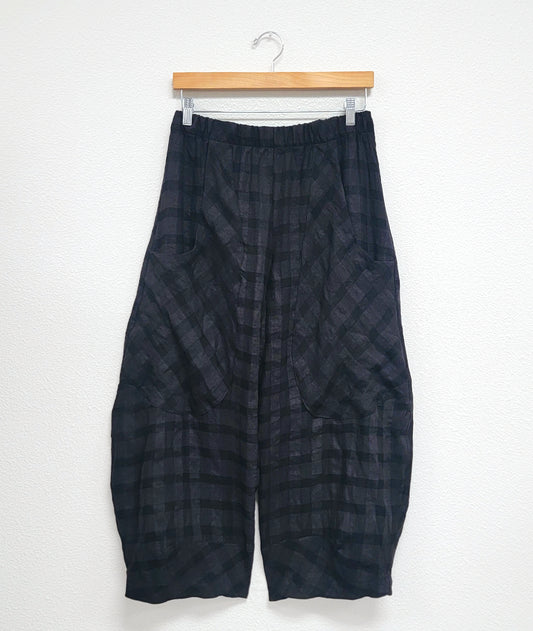 black, large plaid print wide leg pant with a tapered ankle, oversized exterior pockets, and an elastic waistband