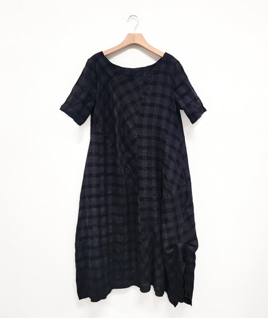 large check print dress with an asymmetrical body, round neckline, elbow length sleeves, and contrasting panels across the body
