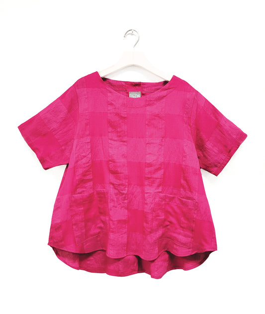 hot pink top in a extra large grid print with a round collar, short sleeves, two squared hip pockets and a buttoned placket up the back