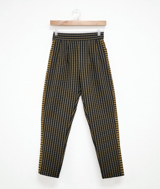 straight cut black crop pants with a yellow grid print. tuxedo stripes on the sides in a reverse of the main body fabric.
