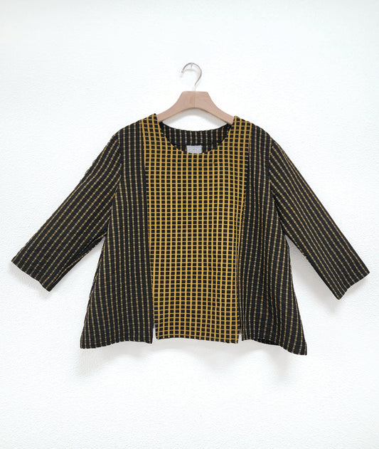 pullover black top with a yellow grid print, 3/4 sleeves, and contrasting center panels in the front and back. contrast is a reverse of the rest of the fabric