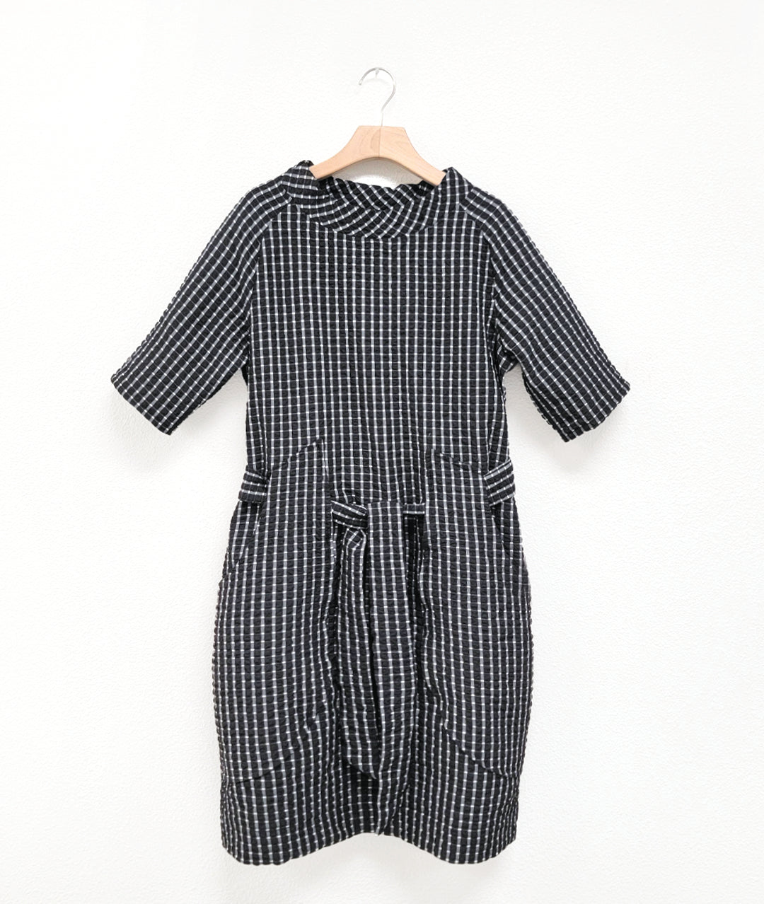 black and white mini plaid raglan sleeve shift dress with a matching tie belt at the waist, which runs through exterior pocket loops