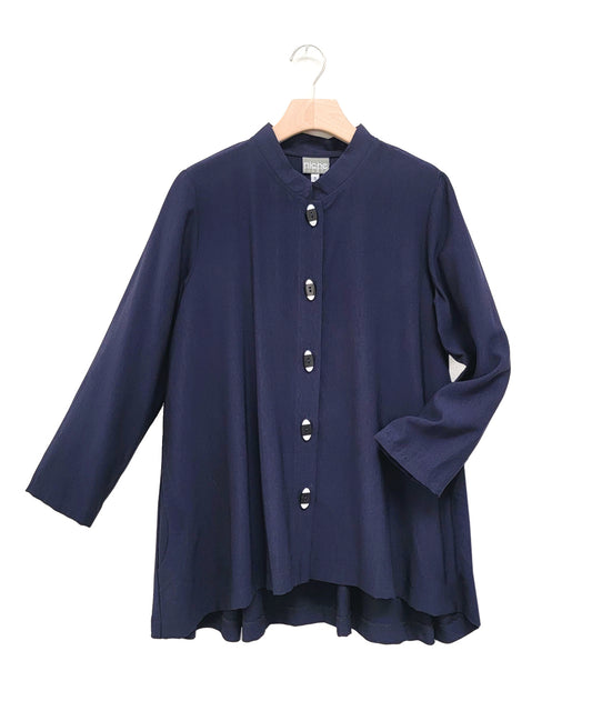 long, navy button down blouse with black and white oval shaped buttons. blouse has rounded pockets, long sleeves and a mandarin collar. 