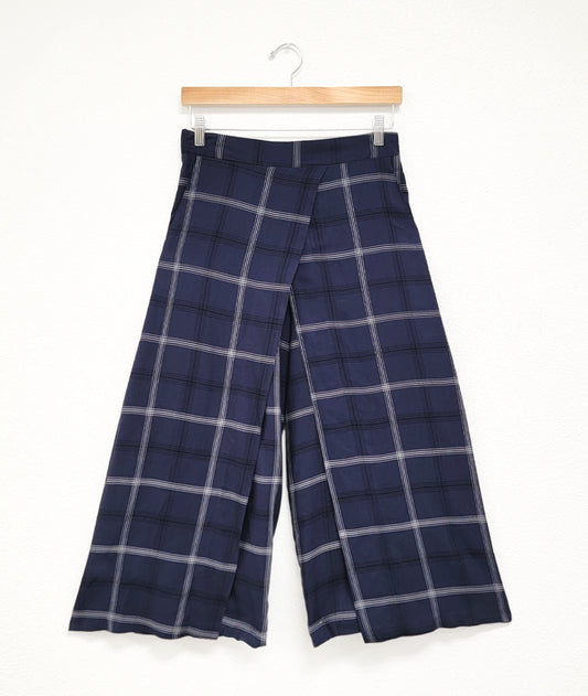 wide leg navy pant with an overlapping panel in the front on either leg. plant is navy blue with a black and white plaid stripe