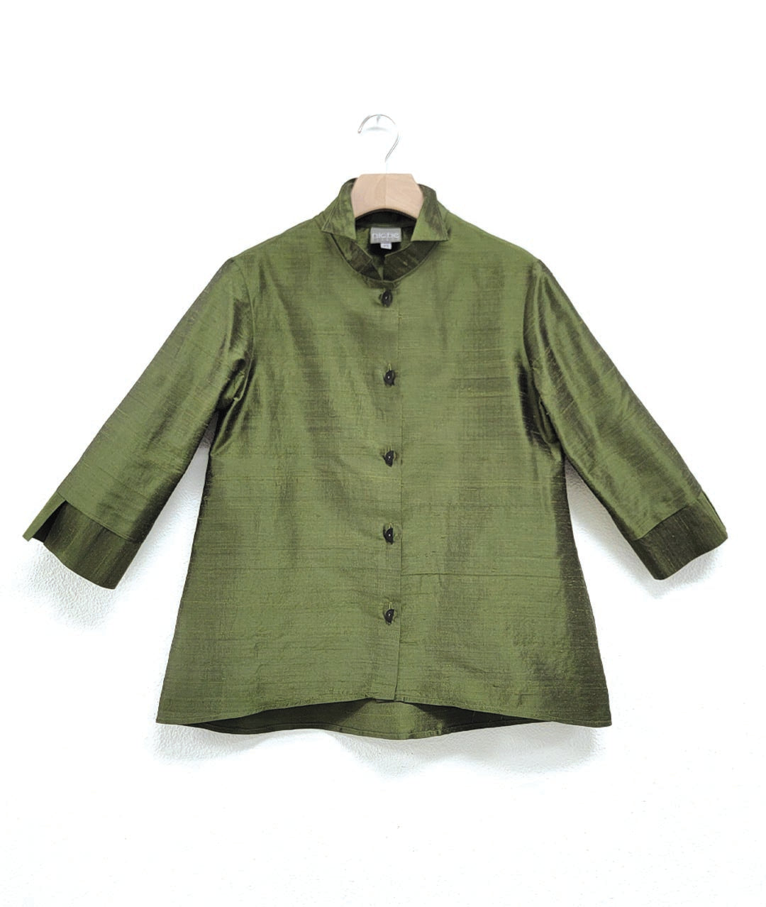 green dupioni silk blouse with black half-moon buttons, a wide cuff on a 3/4 sleeve, and a double collar. blouse has a lower hem in the back.