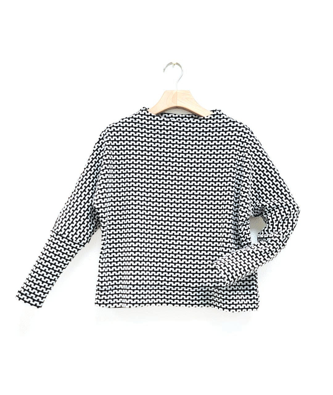 black and white zipper knit pullover top with a high neckline and dolman sleeves.