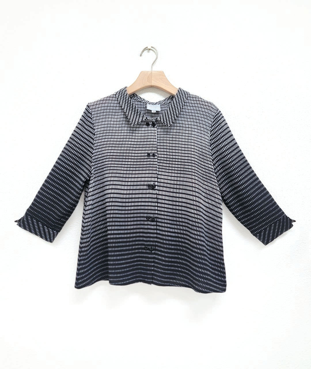 button down blouse with an ombre grid print. blouse has twin buttons, a 3/4 sleeve with a split cuff, and a boxy body