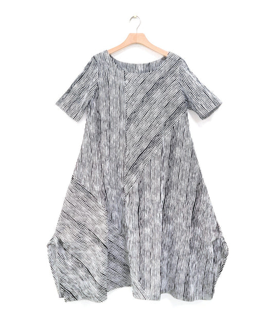 black and white striped dress with contrasting panels of directional stripes. Dress has a round neckline, elbow length sleeves and splits and tucks at the sides