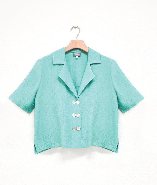 a boxy black button down with an elbow length sleeve and an open collar top has 3 sets of double buttons