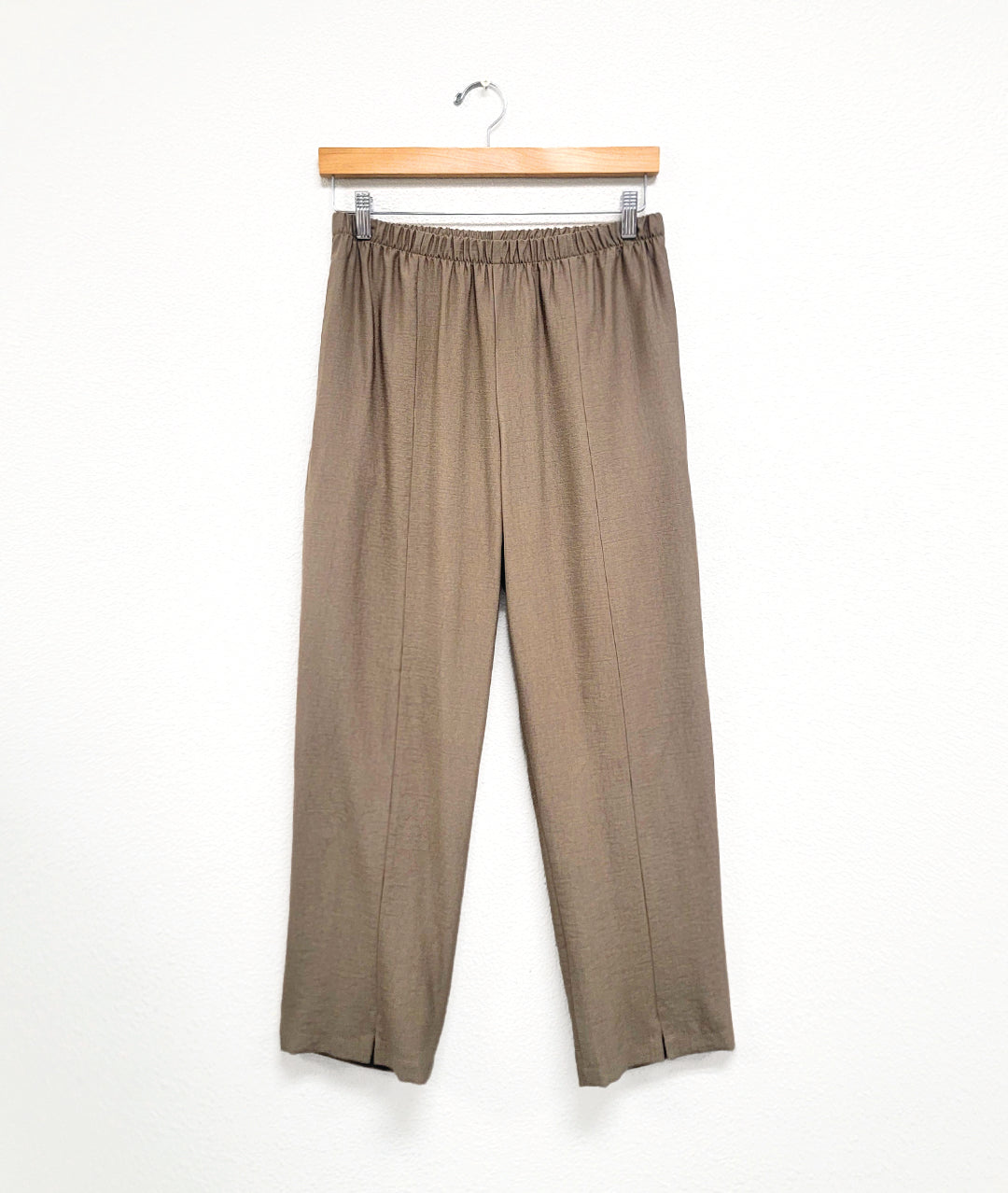 taupe straight cut pants with an elastic waistband and small slits at the ankle