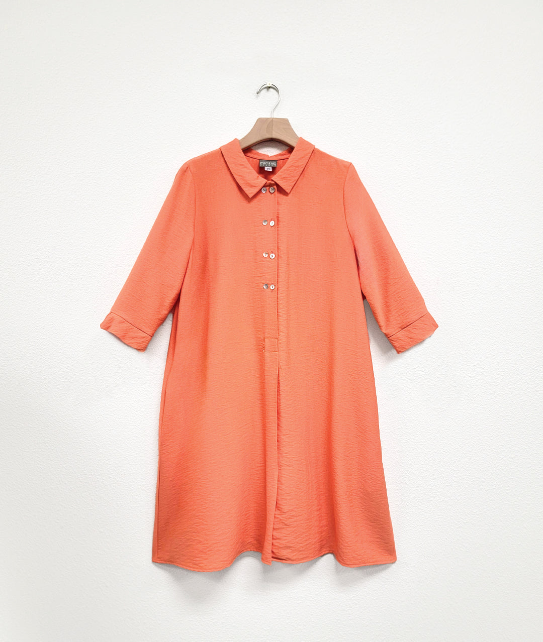 apricot orange twinbutton shirt dress on a hanger