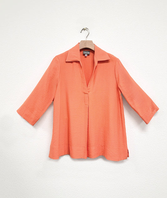 orange pullover top with a deep v and a 3/4 sleeve
