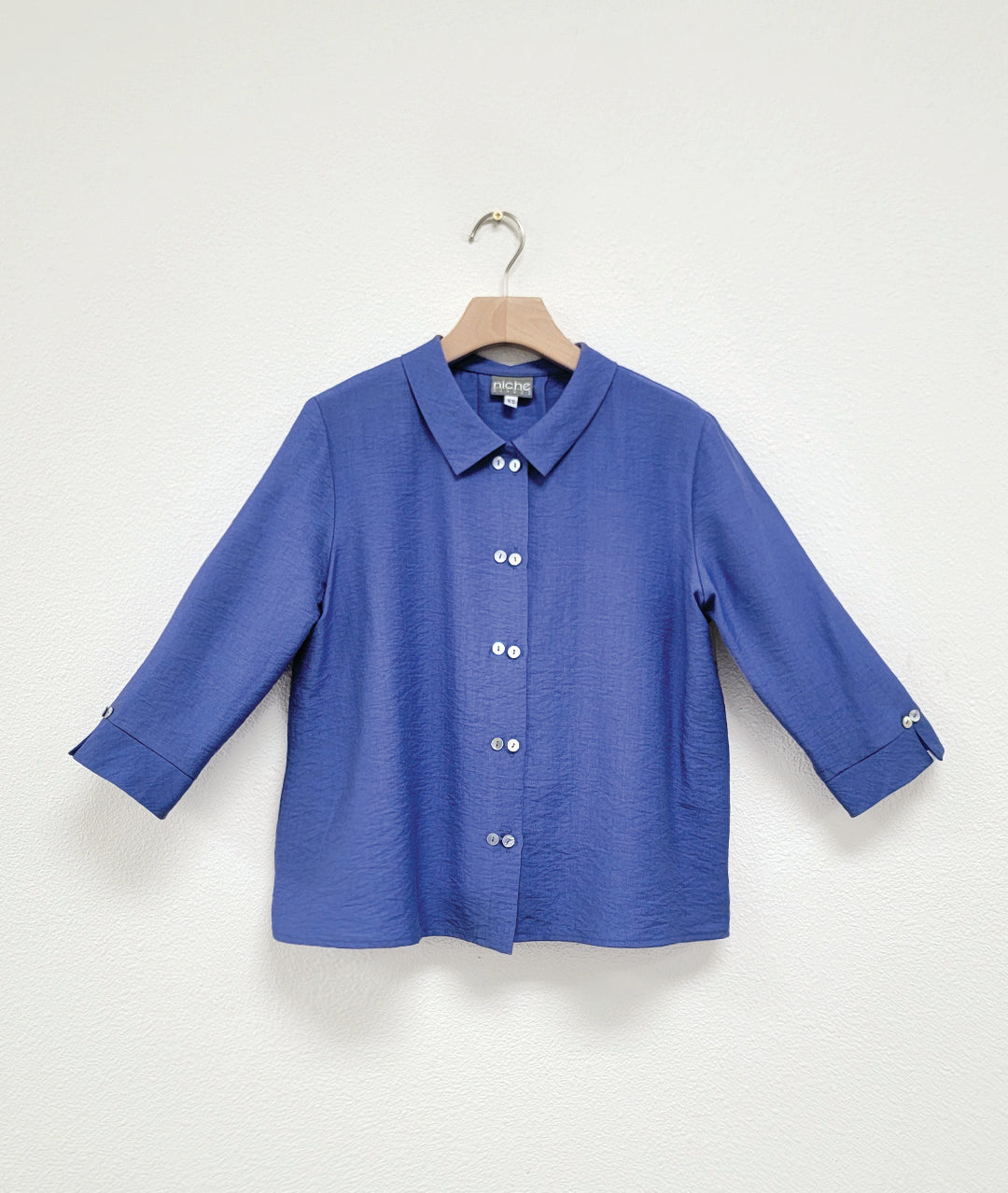 Blue shirt on a hanger against a white background
