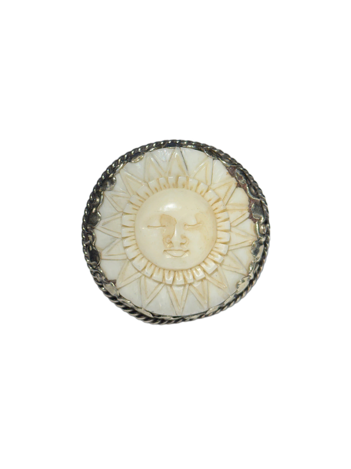 A circular silver ring featuring a carved cream-colored sun face in the center on a plain white background.