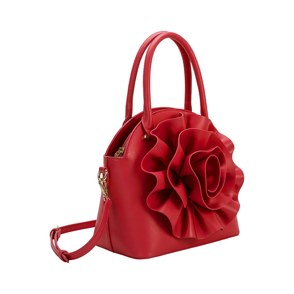 side view of red handbag with large flower detailing and crossbody strap on white background