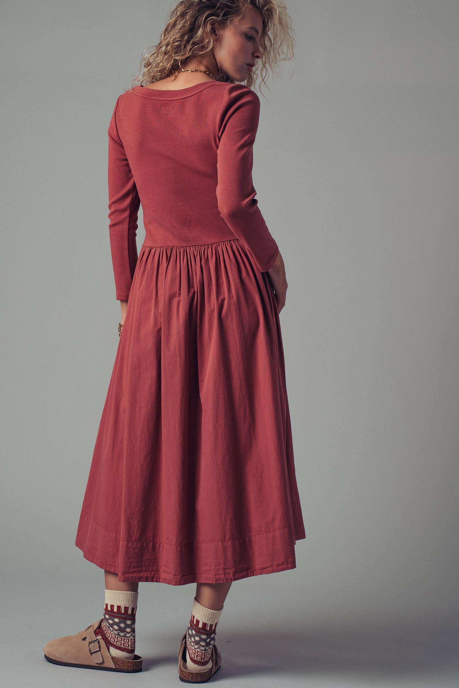 Woman wearing a red dress against a gray background
