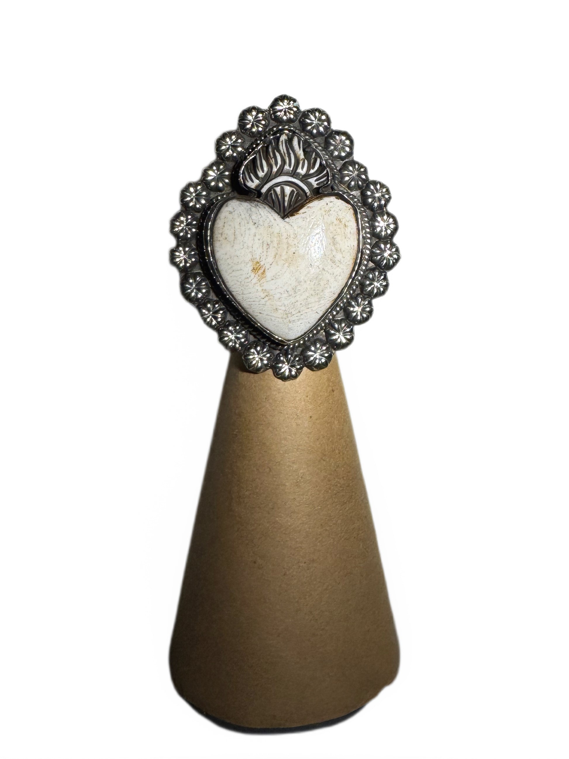 Decorative item with heart-shaped stone and ornate metal frame on a white background