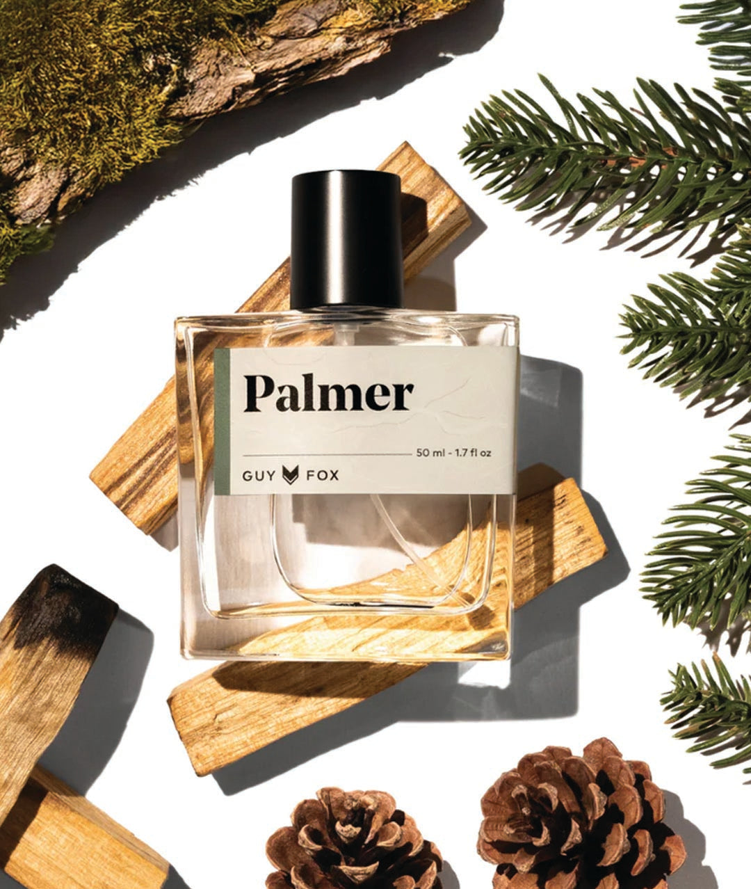 Perfume bottle labeled 'Palmer' by 'GUY FOX' with natural elements like pine cones and wood on a white background.