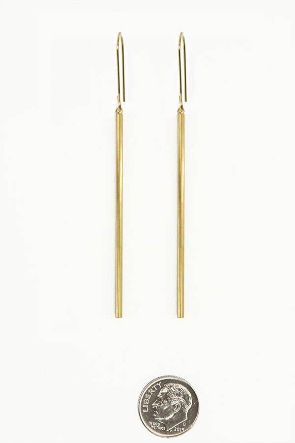 Gold rod earrings on a white background with a dime for scale.