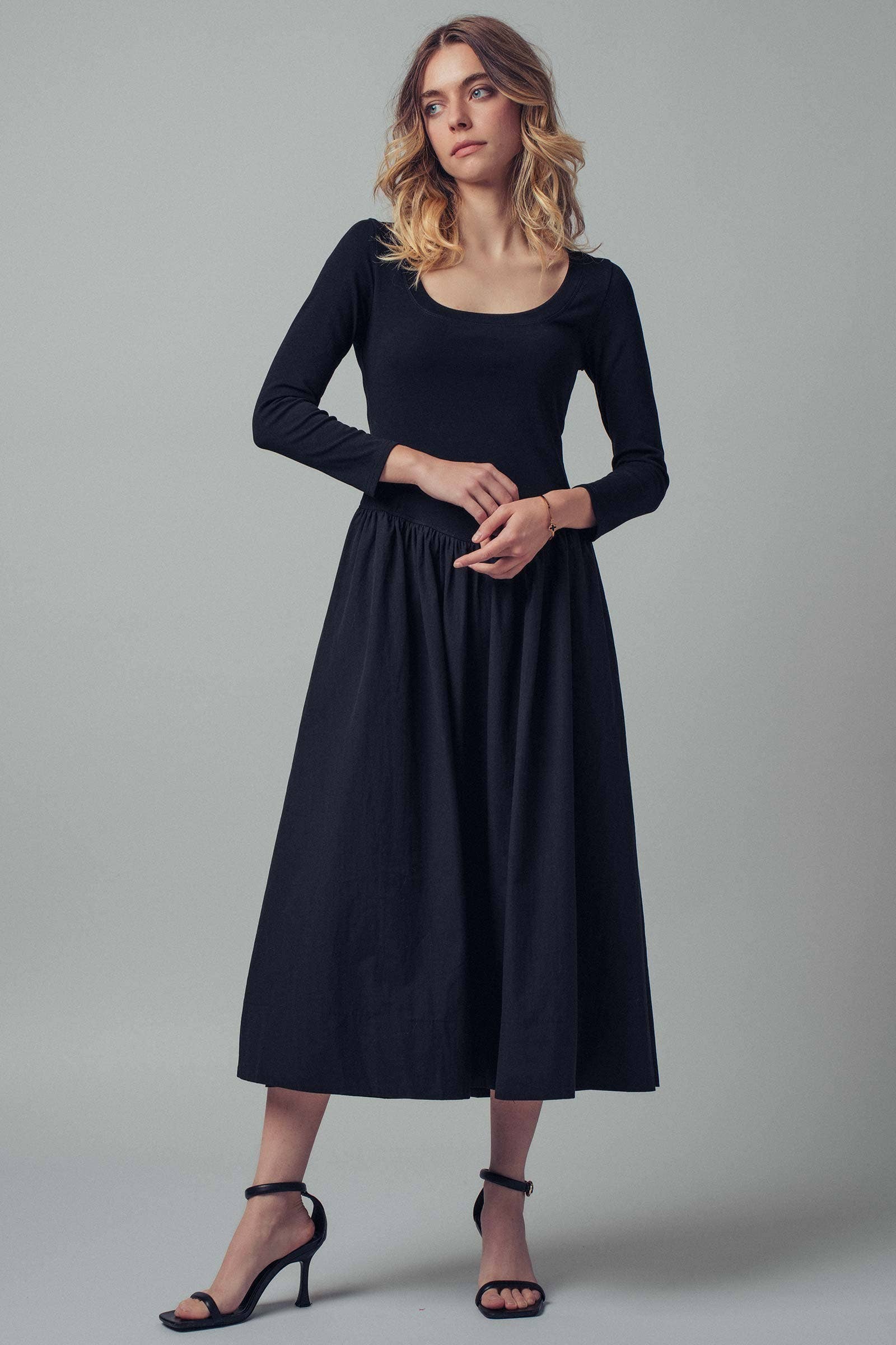 Woman wearing a black dress against a gray background