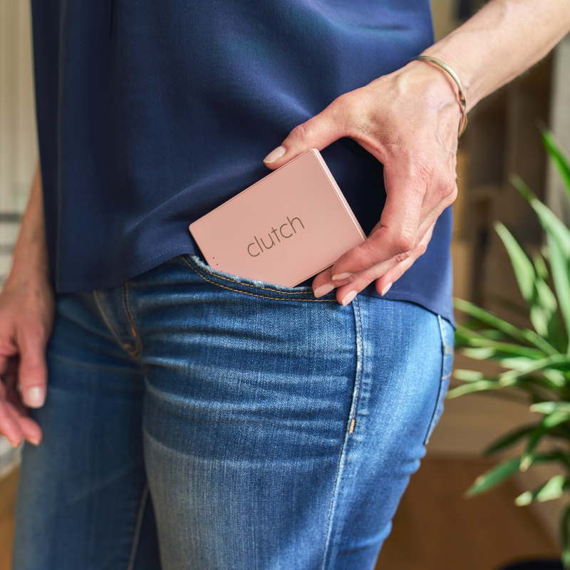 women pulling out pink portable charger from pocket