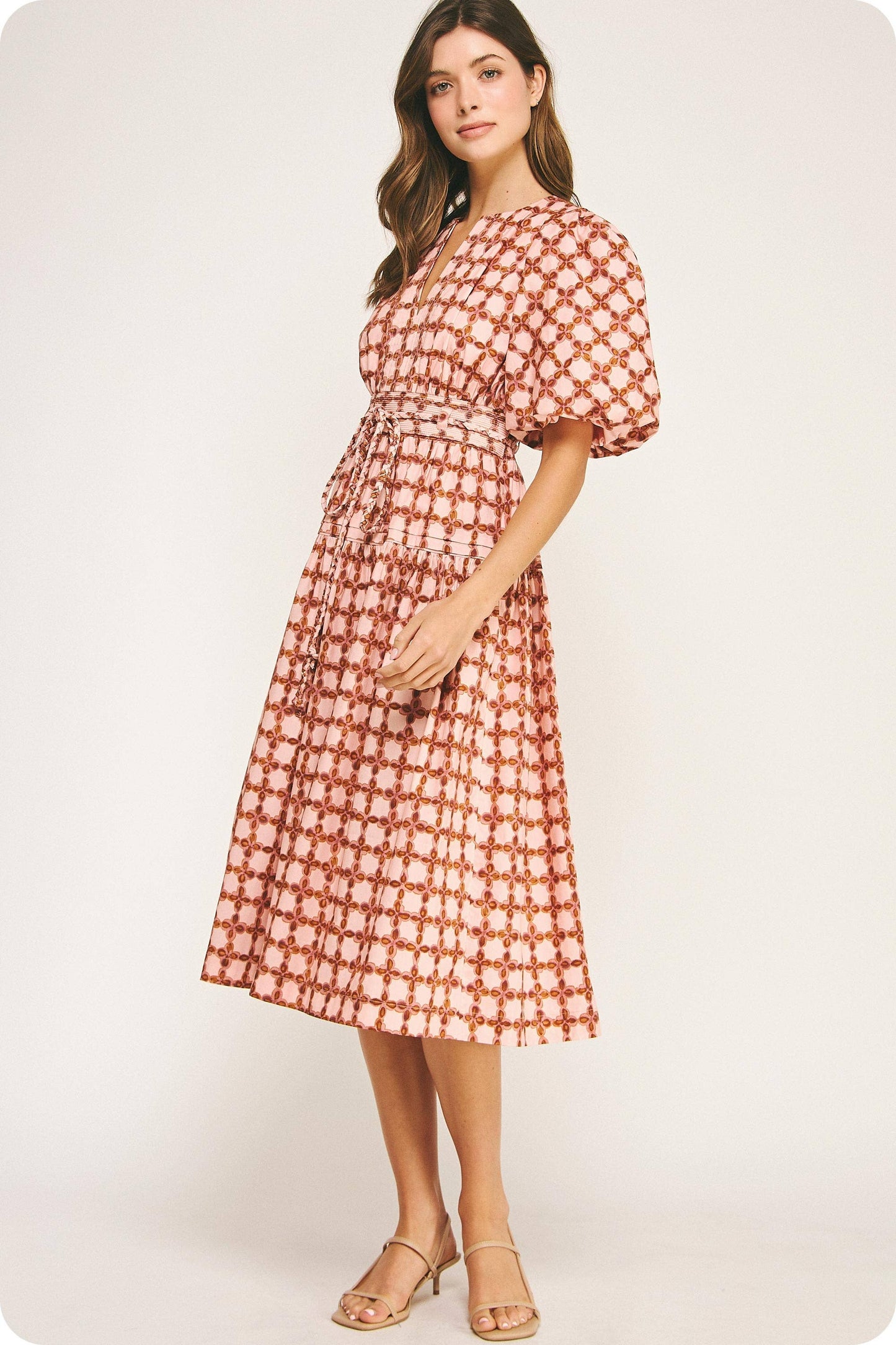 Woman wearing a red and white patterned dress on a white background