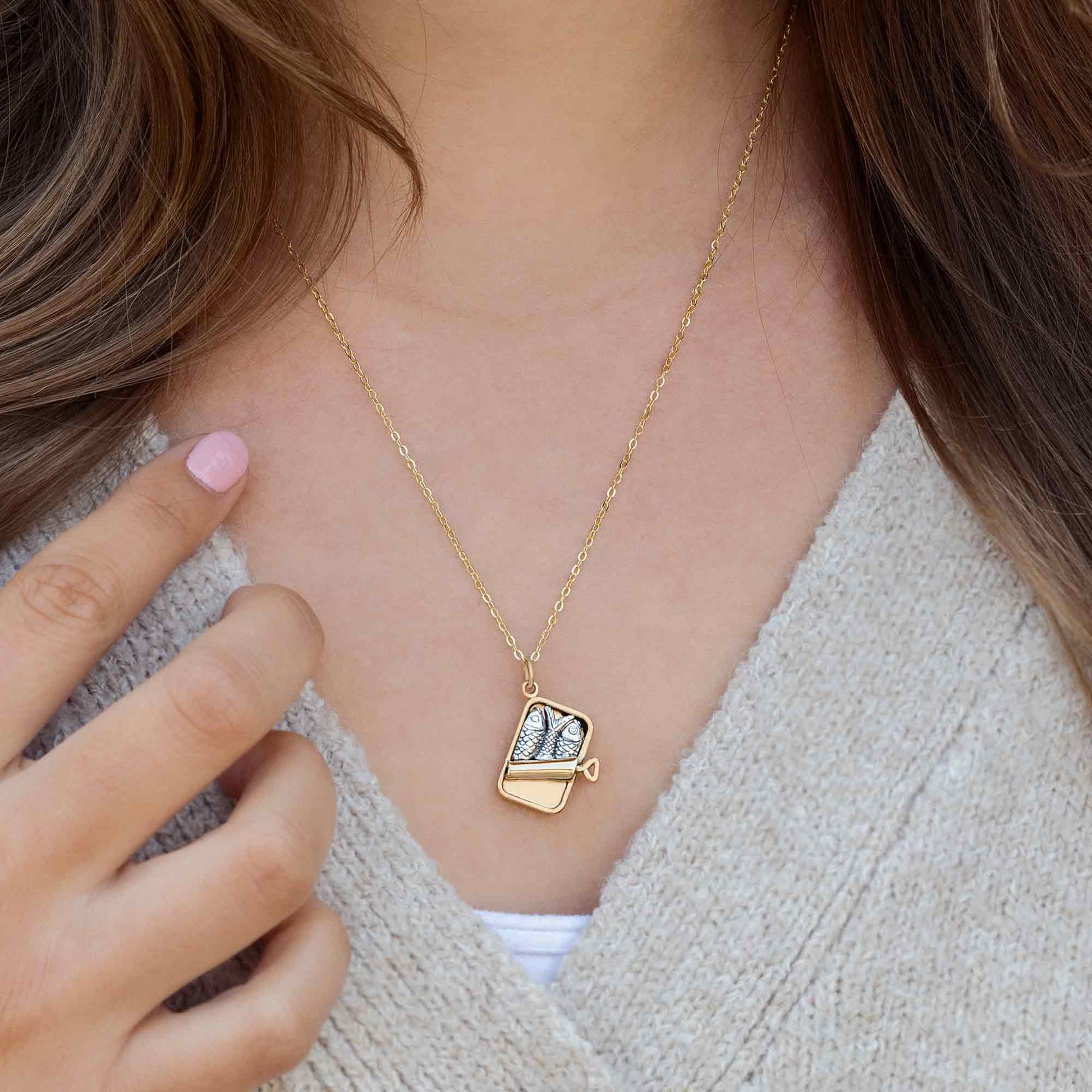 Gold necklace with a pendant worn by a person