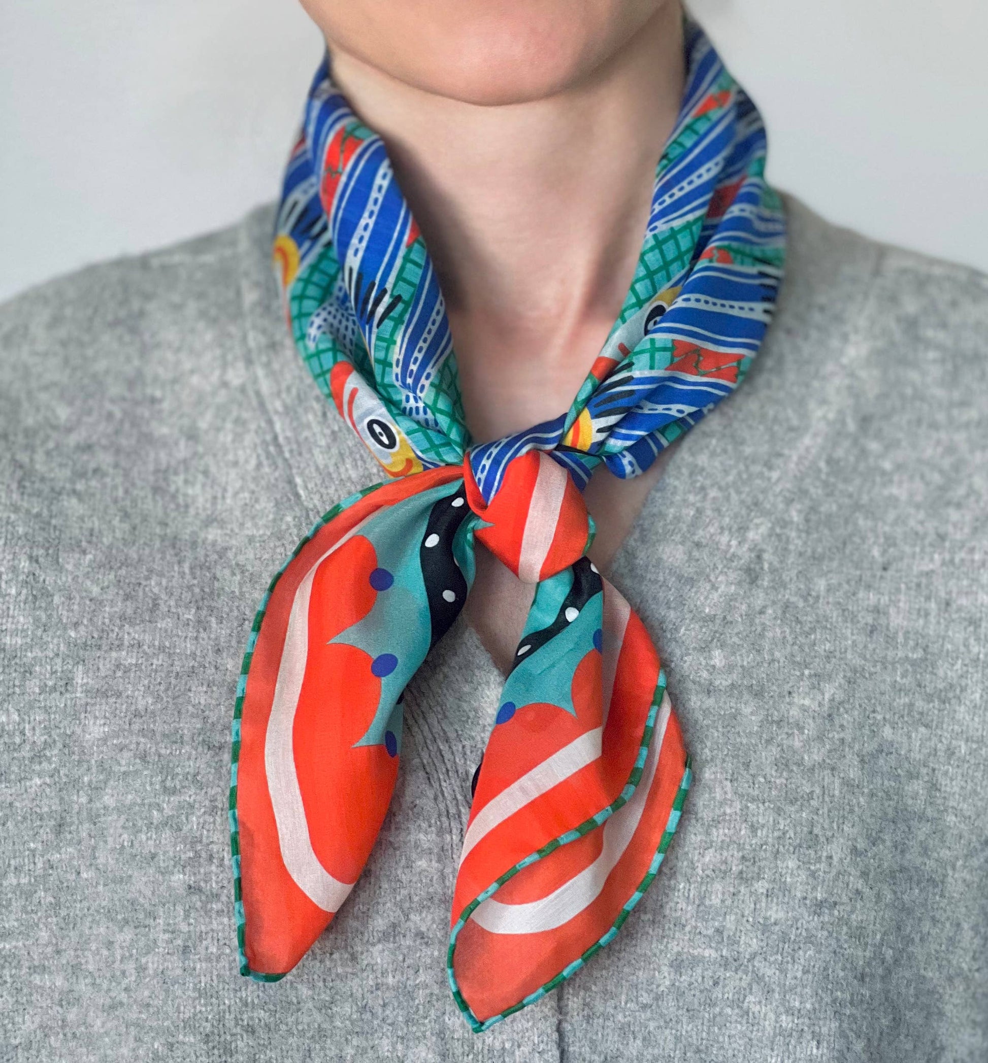 Colorful patterned scarf worn by a person on a plain background