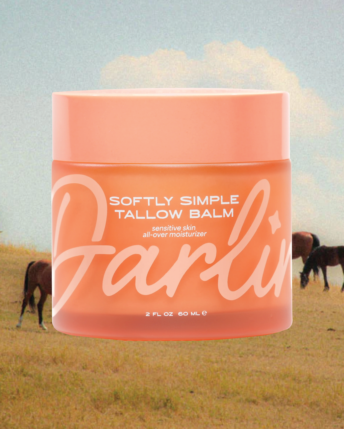 Jar of 'Softly Simple Tallow Balm' with a scenic background of horses in a field.