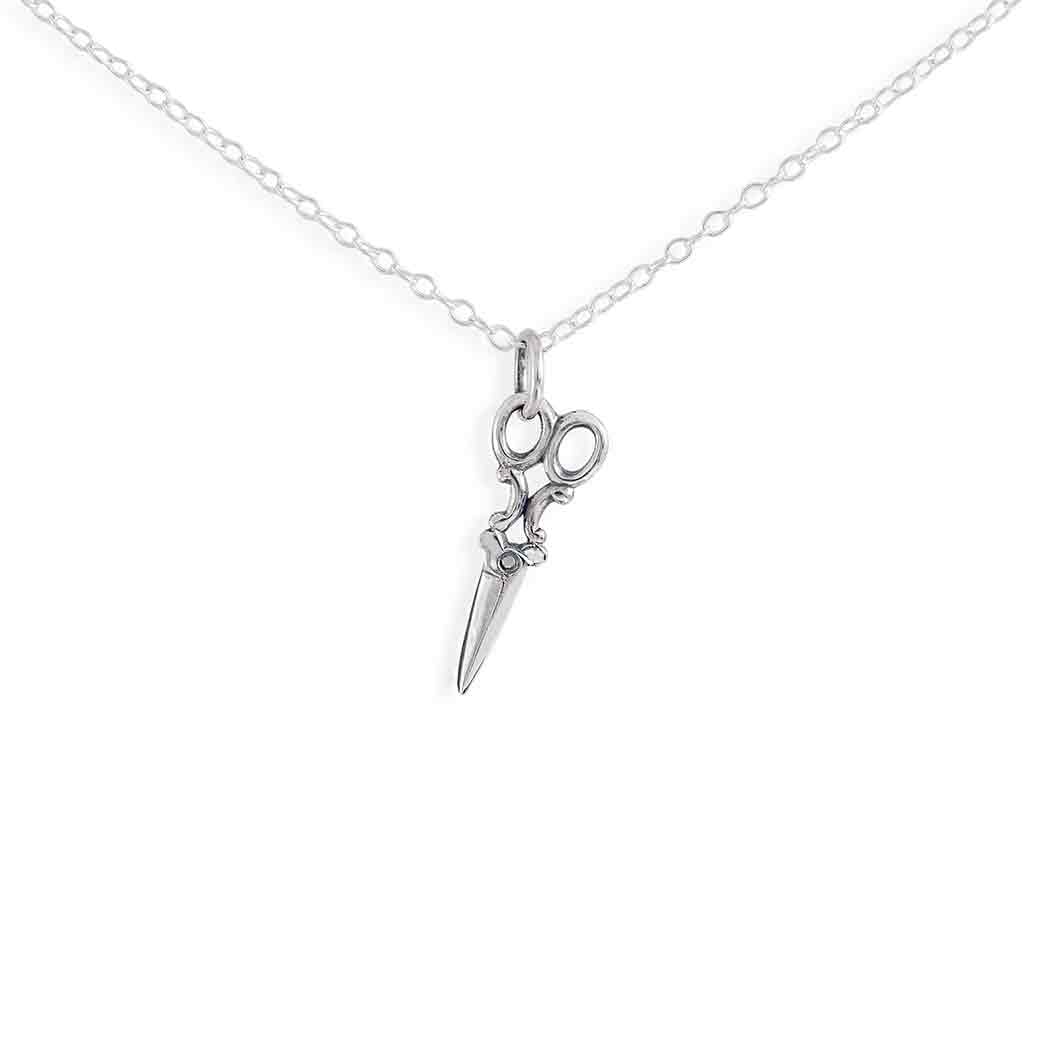 Silver scissors pendant on a chain against a white background