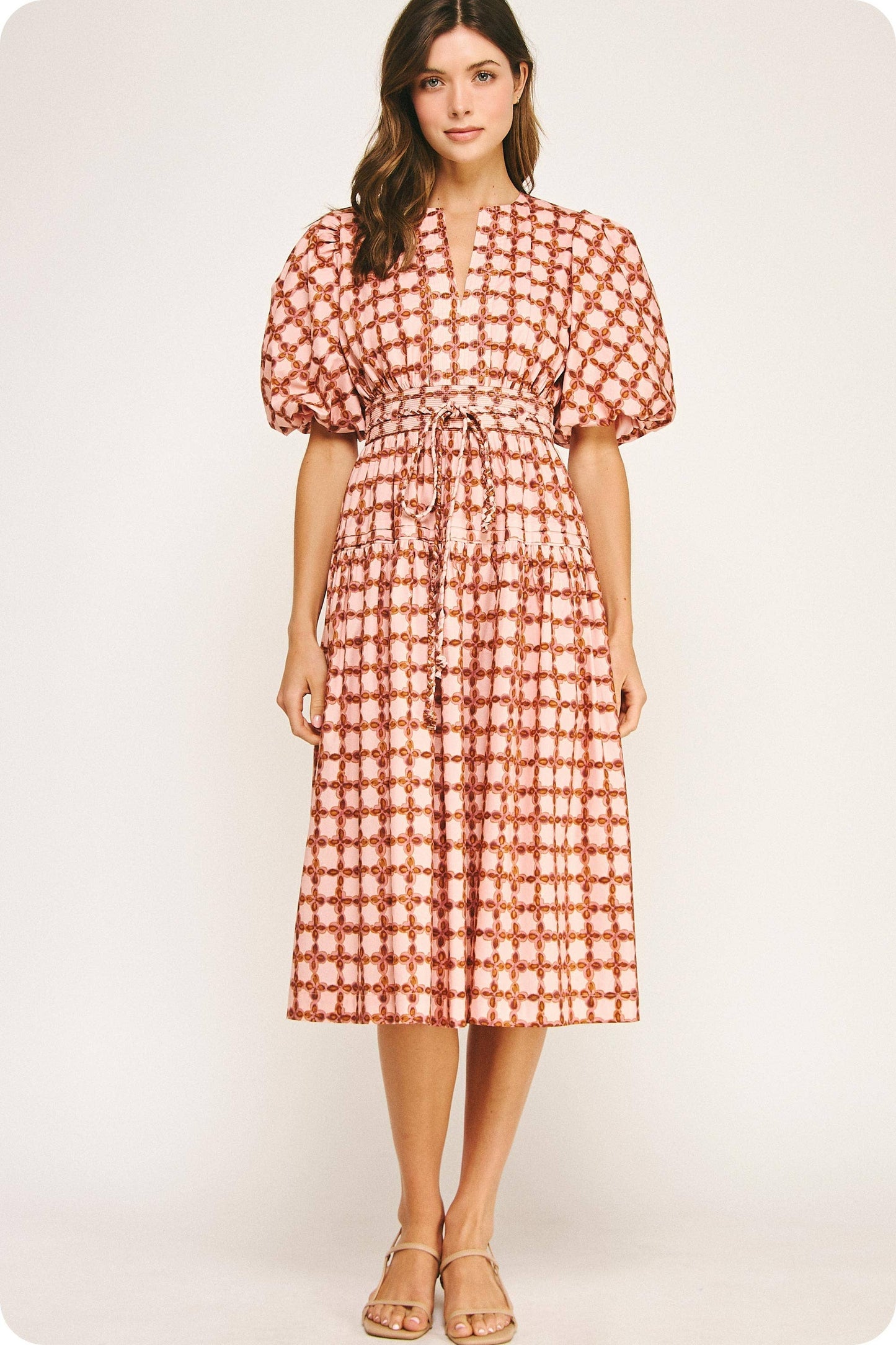Woman wearing a red and white patterned dress on a white background