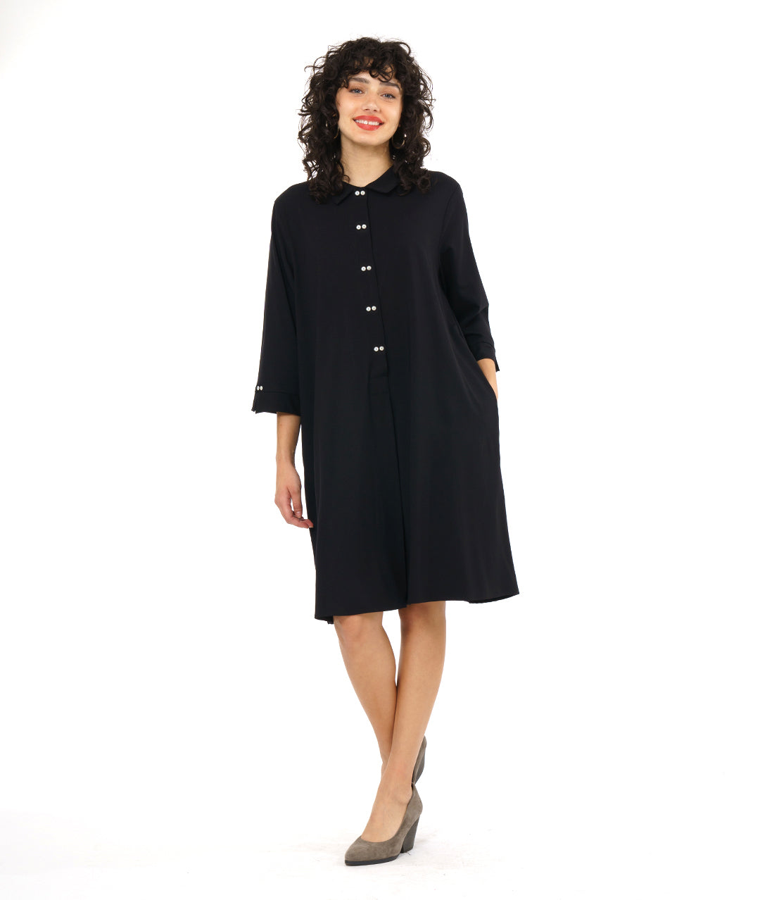 model in a black, knee length button down shirt dress with 3/4 sleeves and a twin button detail