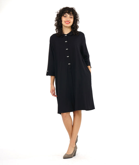 model in a black, knee length button down shirt dress with 3/4 sleeves and a twin button detail