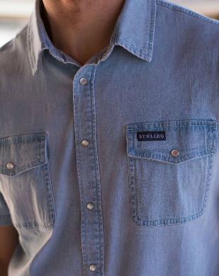 close up of male model wearing short sleeve light blue denim pearl snap shirt 