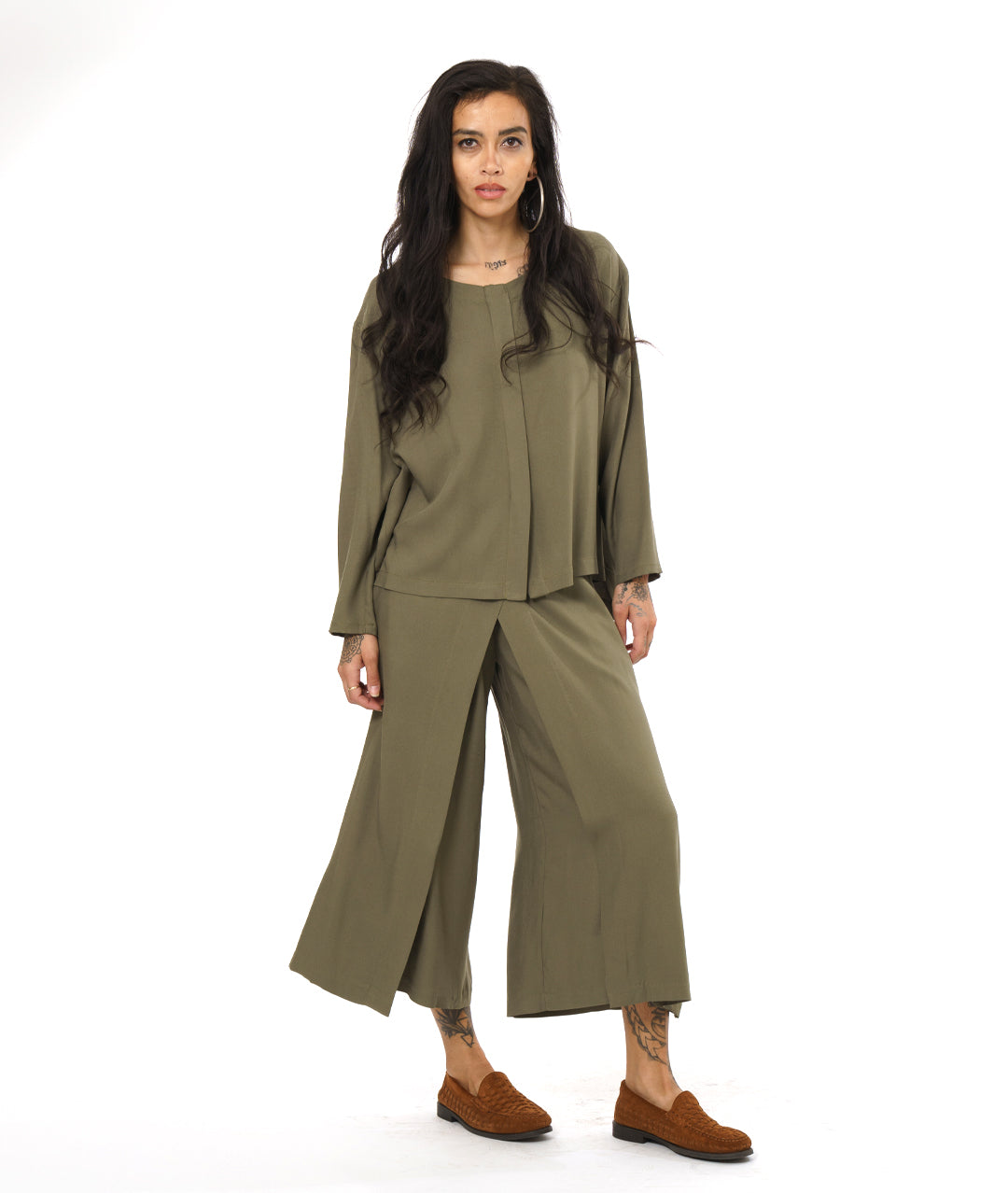 model in an olive green wide leg pant with an overlay in the front, with a matching long sleeve top with a false placket 