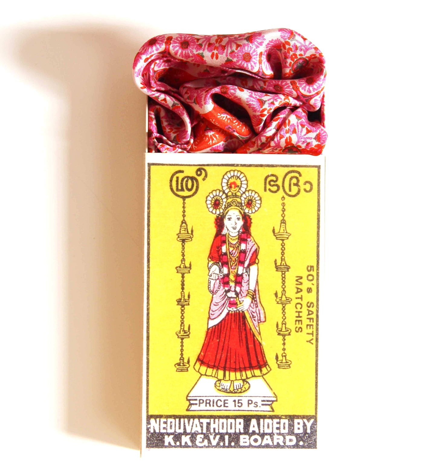 Matchbox with a colorful design featuring a woman in traditional attire on a yellow background.